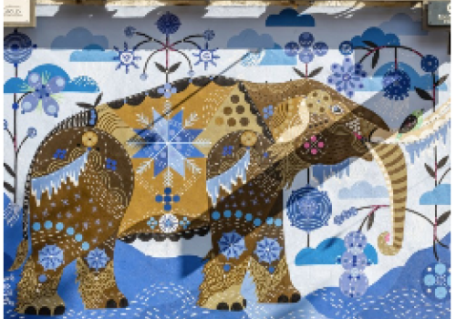 The image shows a colorful mural of an elephant with intricate patterns, set against a background of blue and white floral designs.