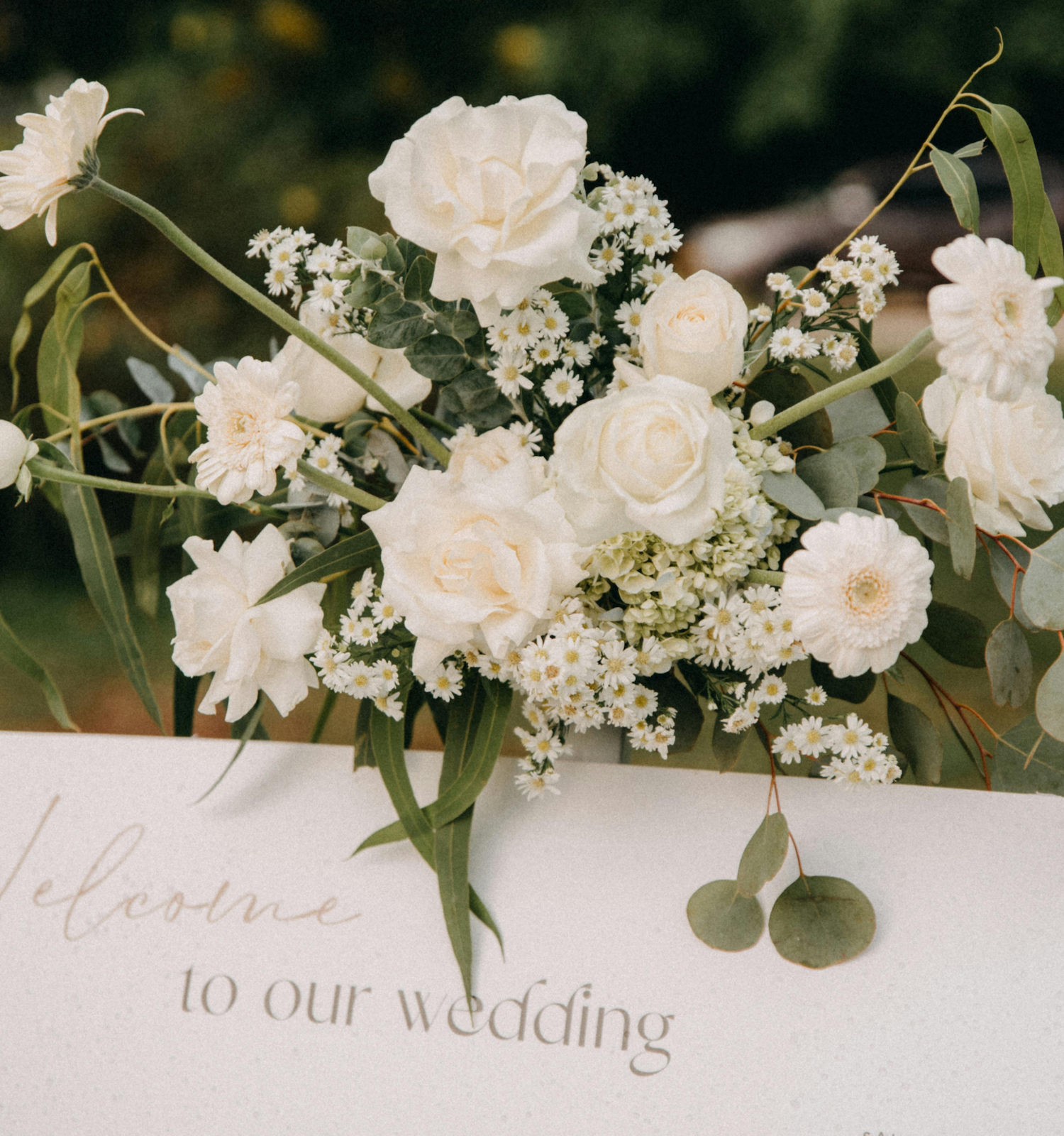 White wedding bouquet with roses and baby's breath on a welcome sign, elegant and romantic for the ceremony.